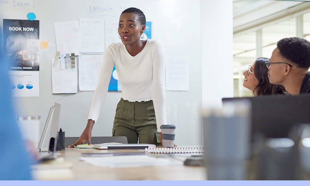 A woman standing and talking in a meeting.