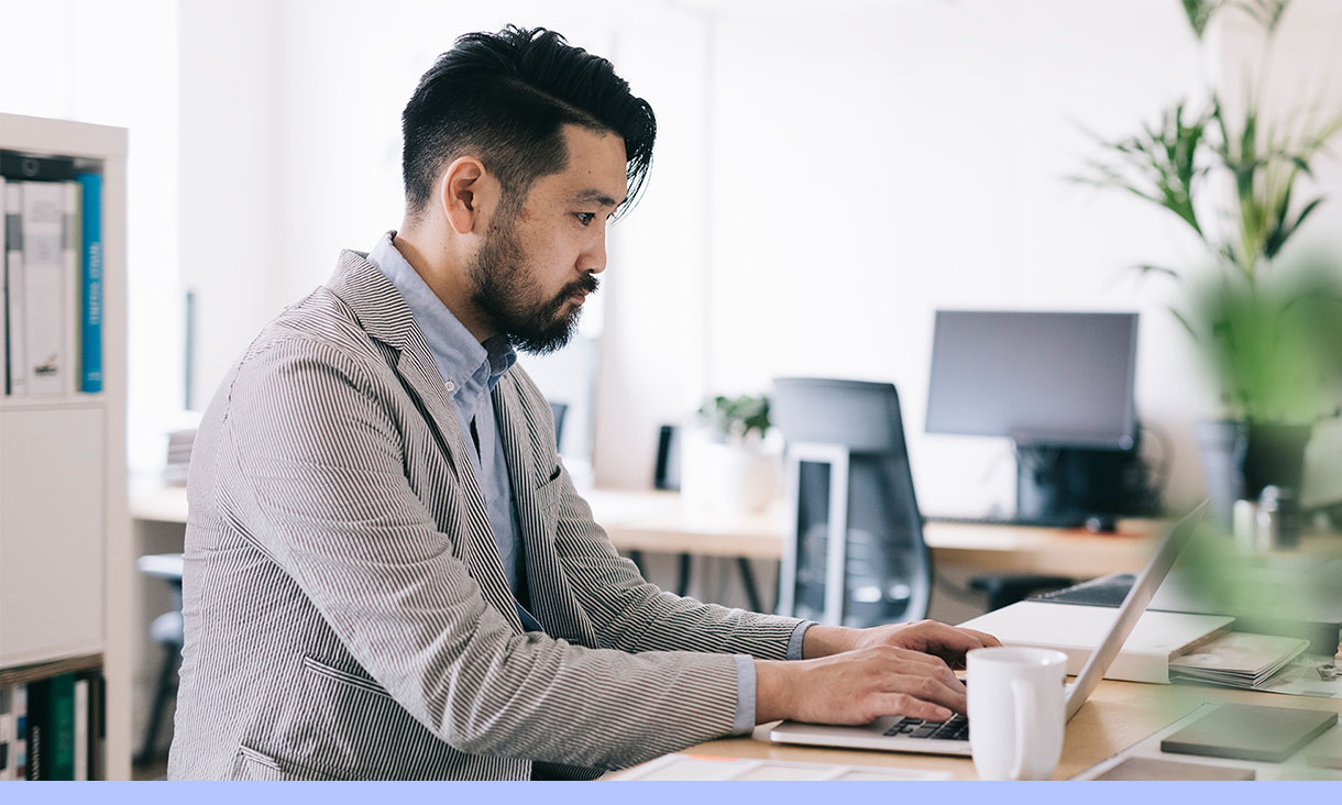 A man works at his desk in an office.