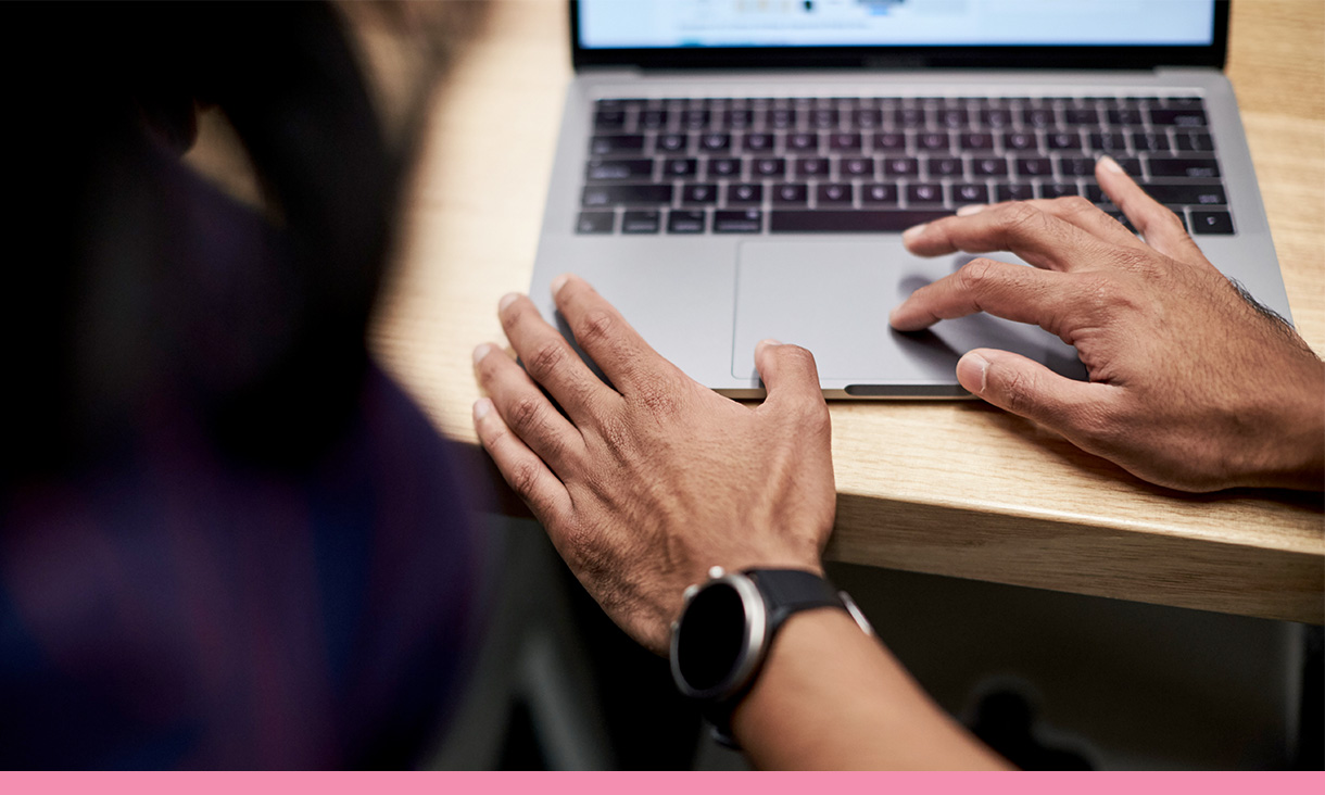A pair of hands using a laptop.