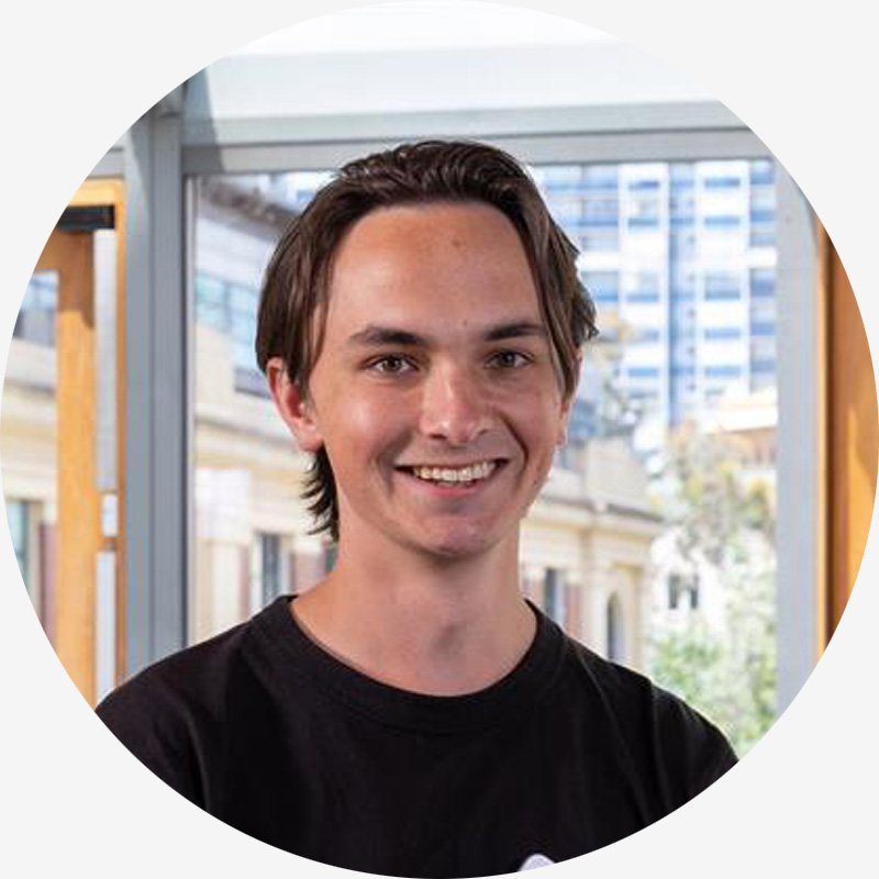 Portrait of Harry Porter, he has brown hair, brown eyes, and is wearing a black t-shirt.