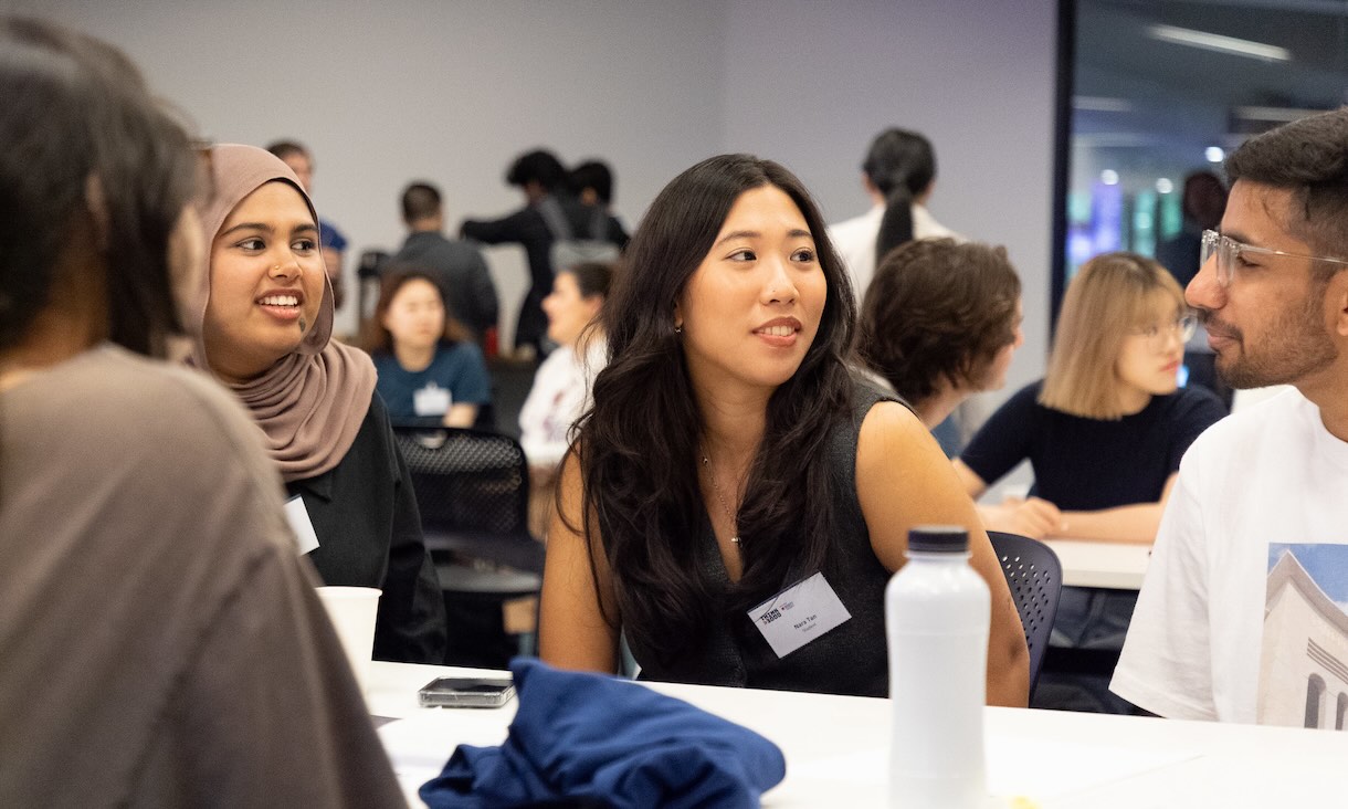 Students at a table talking and smiling