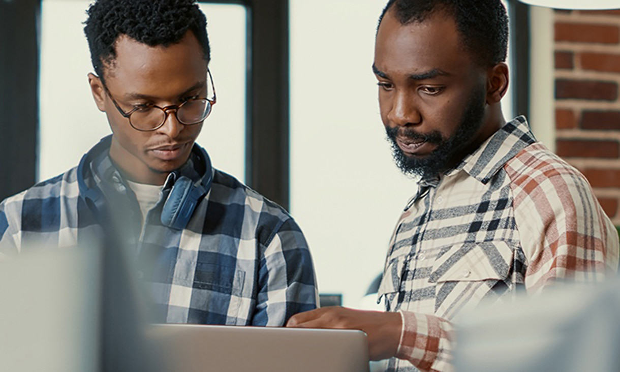 Two men looking at a laptop screen.