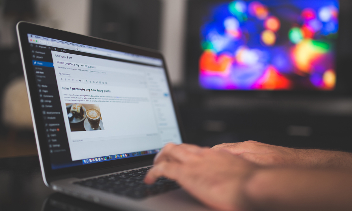man typing using wordpress on laptop